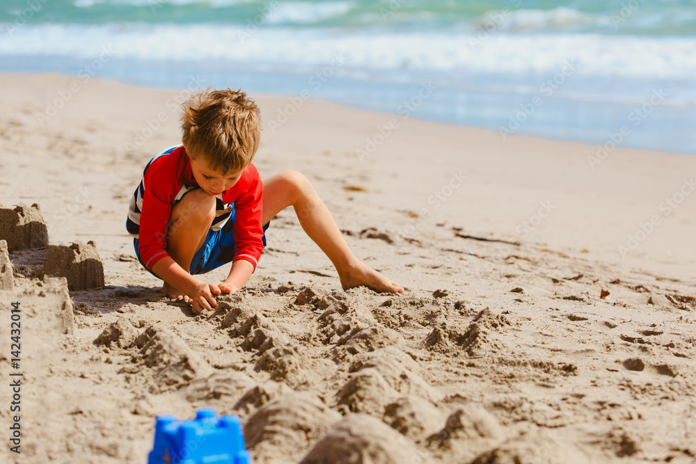 little boy play with sand on summer beach little boy play with sand on summer beach