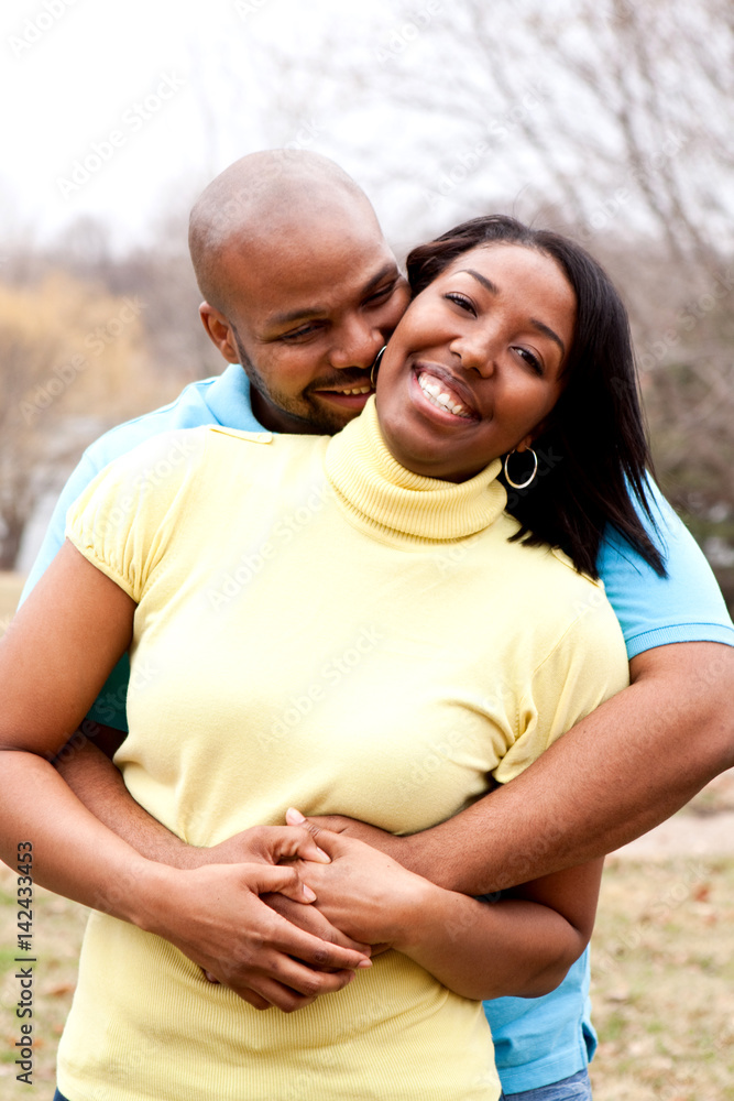 Loving happy African American couple hugging and smiling.