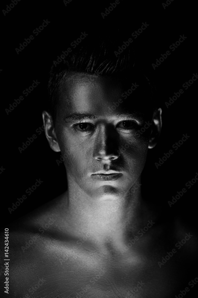 A handsome man of athletic build, completely covered in gold paint.Studio photos, With Hard lite, Black and white