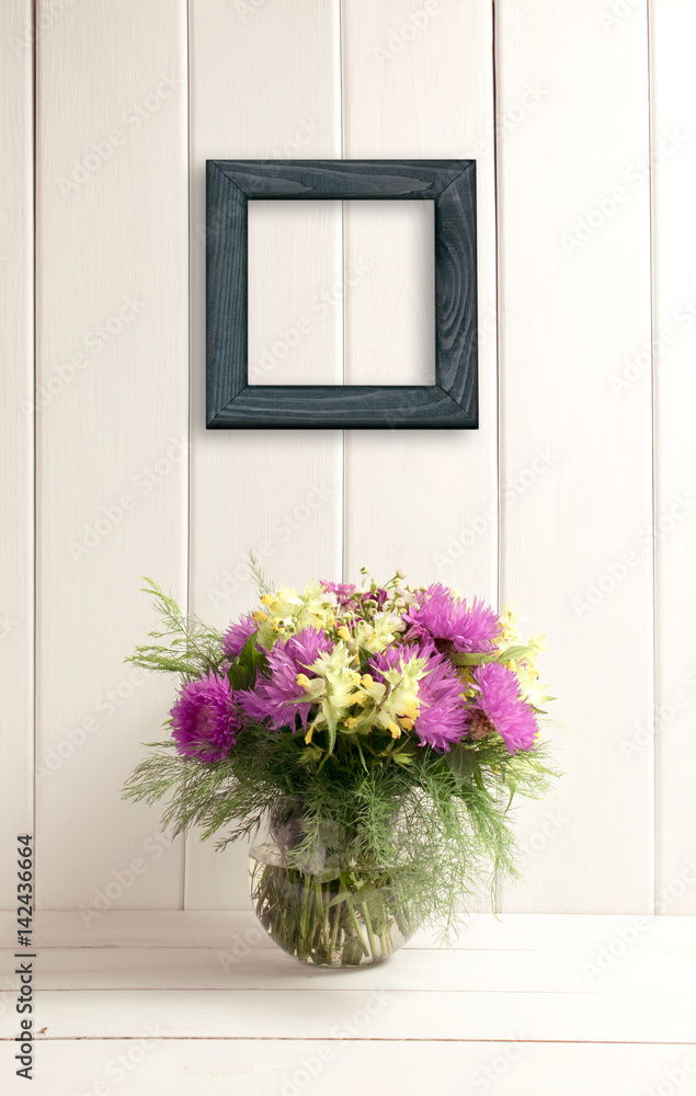 Flower bouquet in glass round vase on background of white wooden planks in provence style Flower bouquet in glass round vase on background of white wooden planks in provence style