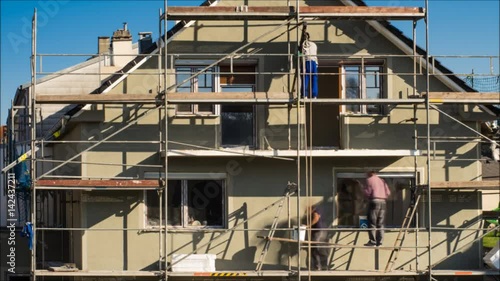 Zeitraffer Baustelle Haus mit Baugerüst und Handwerkern bei der Arbeit – Timelaps construction site house with scaffolding craftsmen and plasterer at work