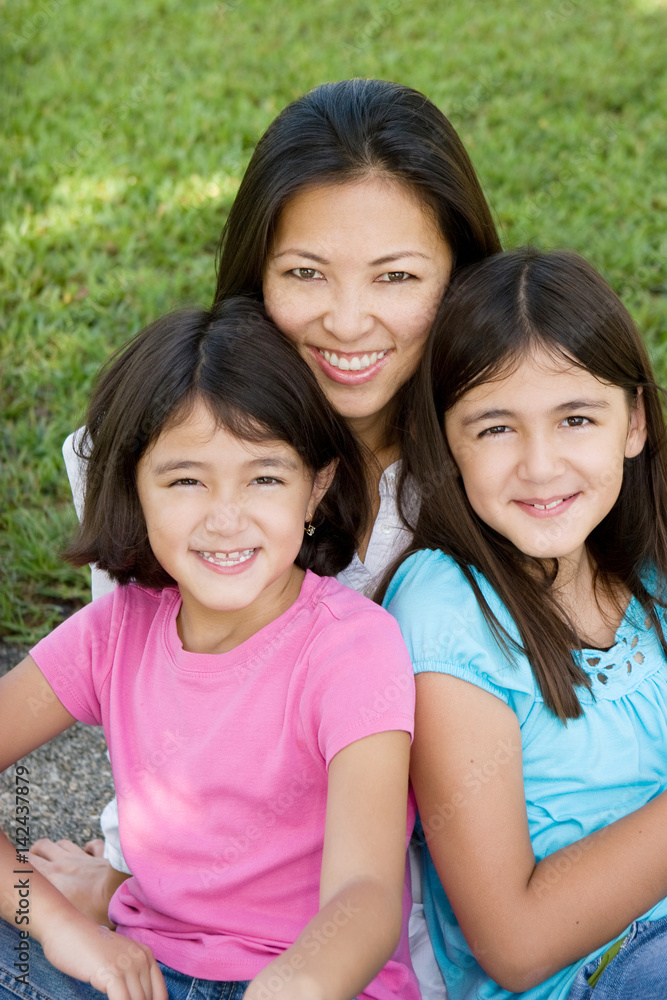 Loving Asain mother and her daughters smiling. Loving Asain mother and her daughters smiling.