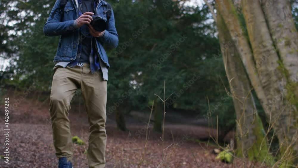4K Photographer takes a photo as he enjoys the view in the forest, in slow motion 4K Photographer takes a photo as he enjoys the view in the forest, in slow motion