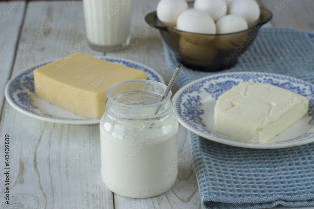 Dairy products on wooden table. Sour cream, milk, cheese, egg, yogurt and butter. Top view Dairy products on wooden table. Sour cream, milk, cheese, egg, yogurt and butter. Top view