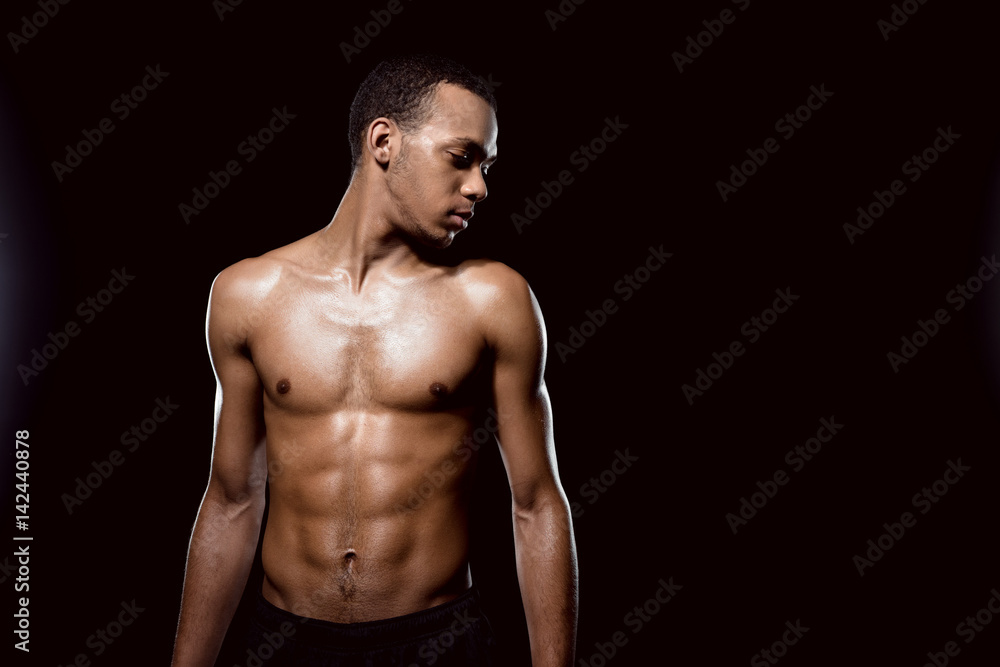Fototapeta premium Handsome african american muscular man posing on black