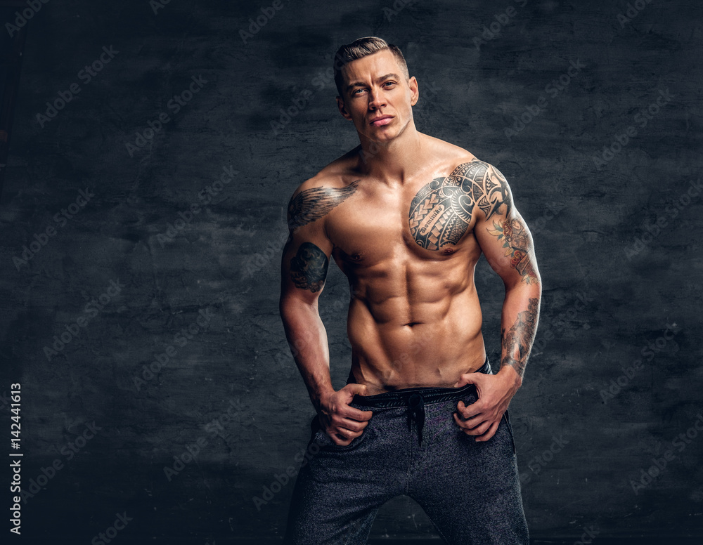 Muscular man fitness model with tattoo on his chest.