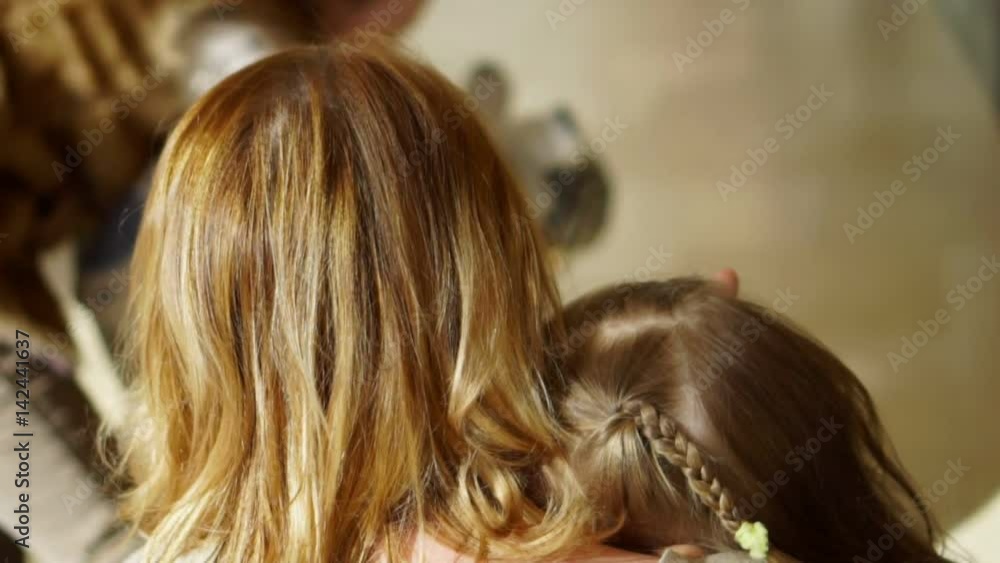 Mother of the little girl irons it on the head Mother of the little girl irons it on the head