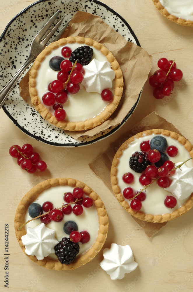 kleine Törtchen mit Vanillecreme, Sommerbeeren und Baiser (Aufsicht) kleine Törtchen mit Vanillecreme, Sommerbeeren und Baiser (Aufsicht)