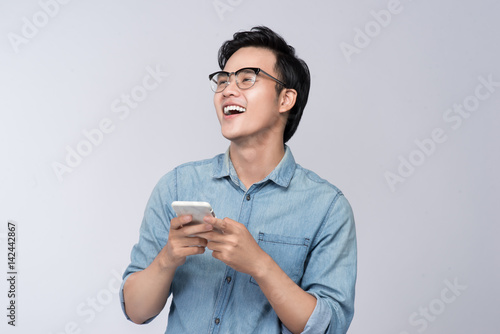 Smart casual asian man using smartphone in studio background photo
