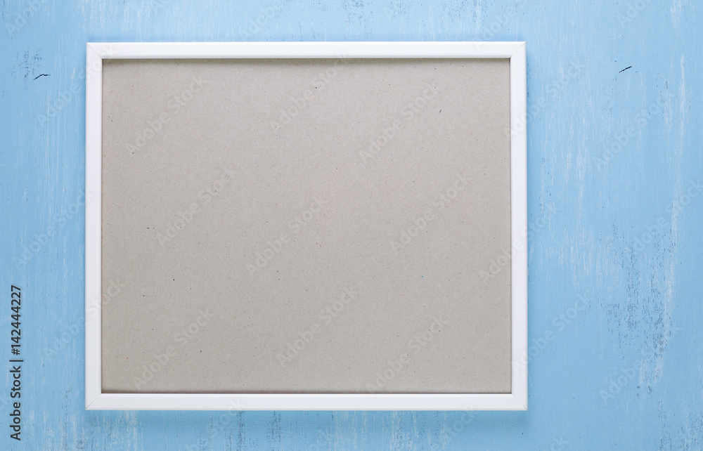 Fototapeta premium Blank photo frame on blue wood background. Painted scraped wooden board. Grunge plywood texture or pattern.