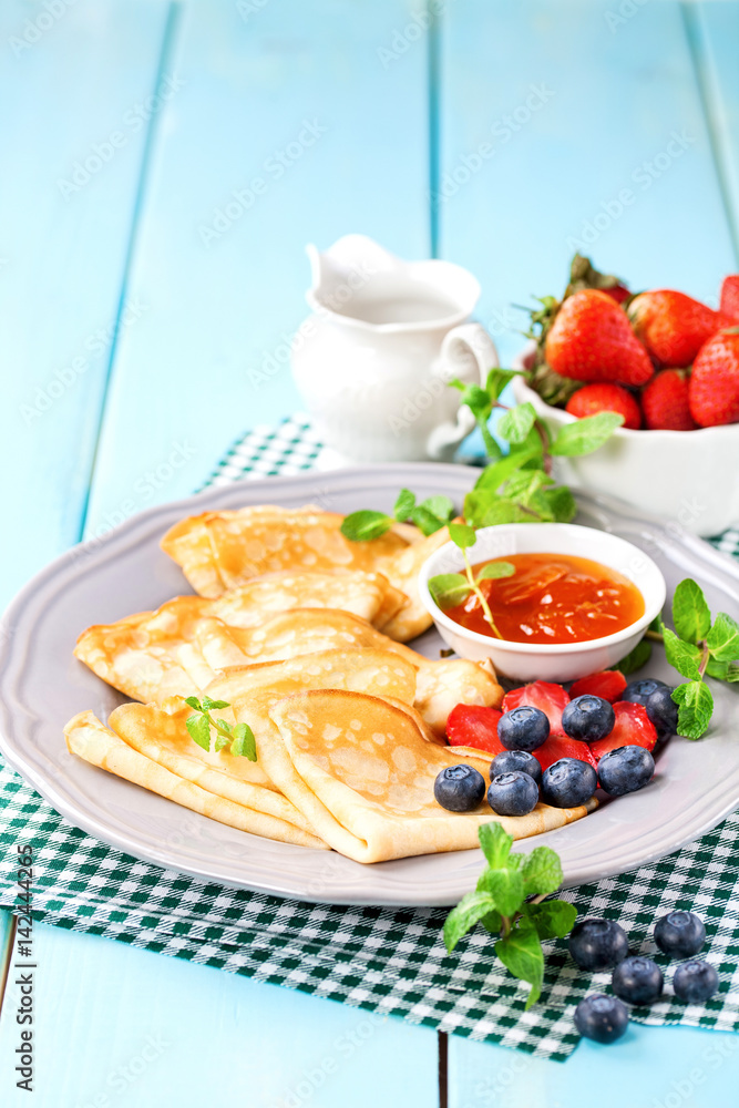 Pancakes with jam and berries on a table. Selective focus. Copy space. Pancakes with jam and berries on a table. Selective focus. Copy space.