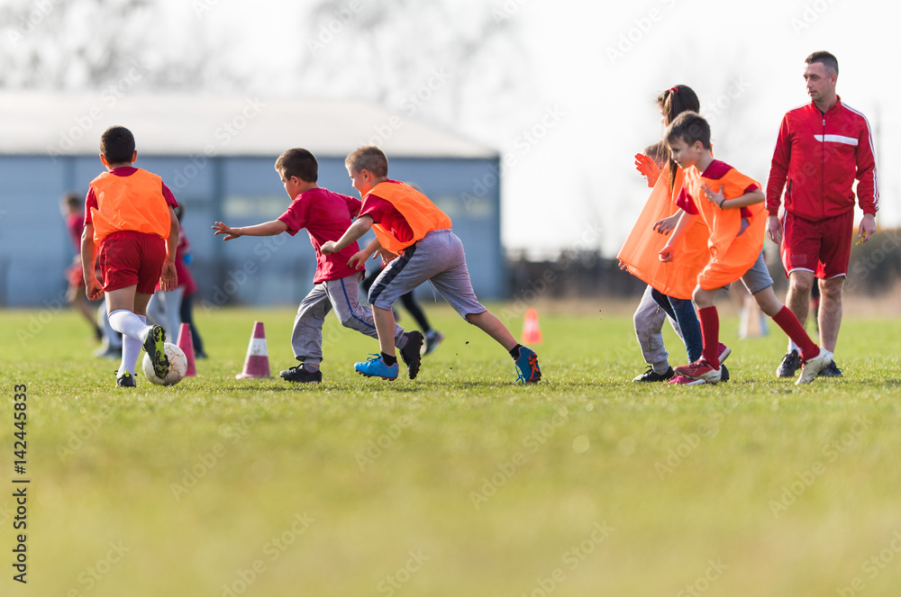 Obraz premium Kids soccer football - children players match on soccer field