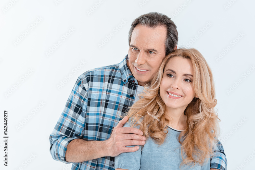 Front view of man and blonde woman embracing and smiling on white Front view of man and blonde woman embracing and smiling on white