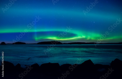 Northern lights dancing over frozen lake in spring © Conny Sjostrom