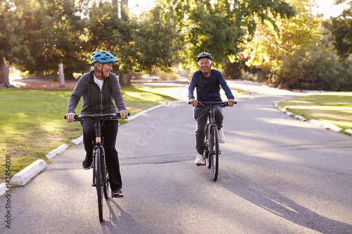 Foto Front View Of Senior Couple Cycling Through Park Together