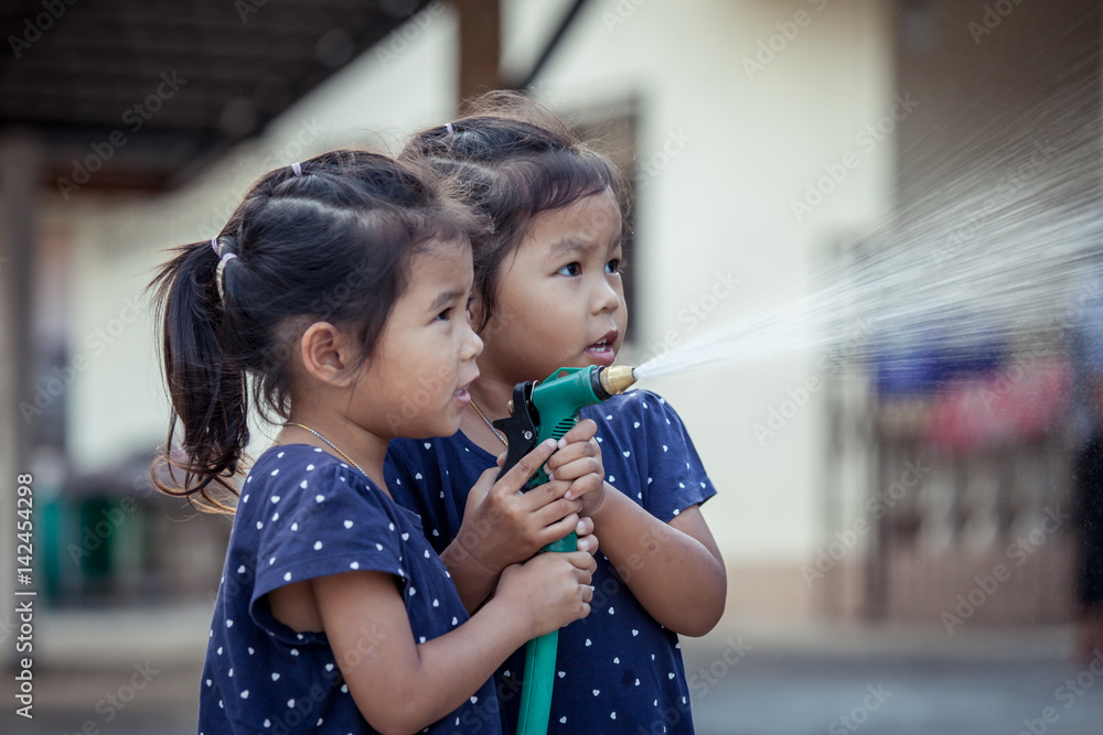 Φωτογραφία two asian little girls helping parent washing a car