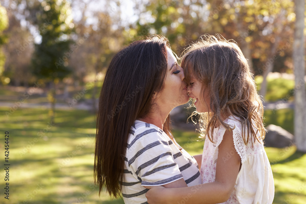 Loving Mother Kissing Daughter In Park Loving Mother Kissing Daughter In Park