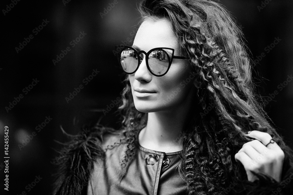 Close-up face portrait of young beautiful woman with perfect skin in Cat's eye sunglasses in the cityscape. Beauty face make-up Close-up face portrait of young beautiful woman with perfect skin in Cat's eye sunglasses in the cityscape. Beauty face make-up
