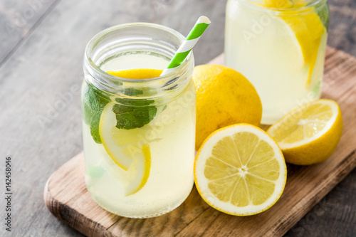 Lemonade drink in a jar glass on wooden background. 