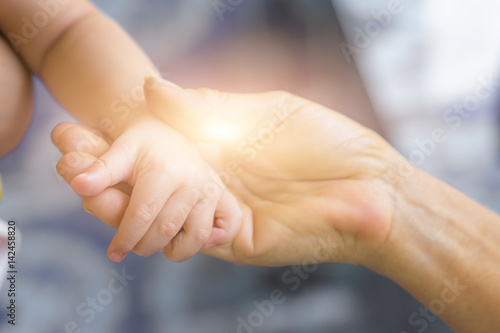 hands of baby grandson and old grandmother, concept of family relationship and passage of time