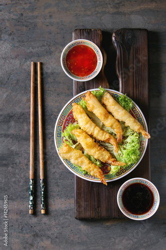 Photography Fried tempura shrimps on lettuce salad with sauces