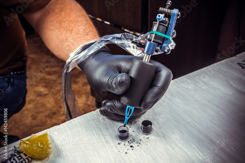 Canvas Print Tattoo master at work in tattoo parlor