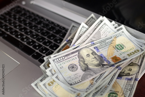 Banknotes over laptop keyboard