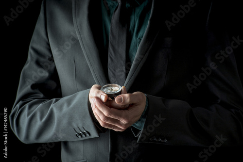 Businessman in suit holding compass in his hands