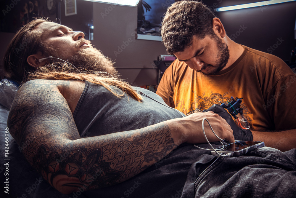Fototapeta premium Master showing process of making a tattoo in studio