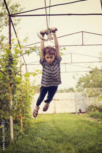 Cool boy swings on rope