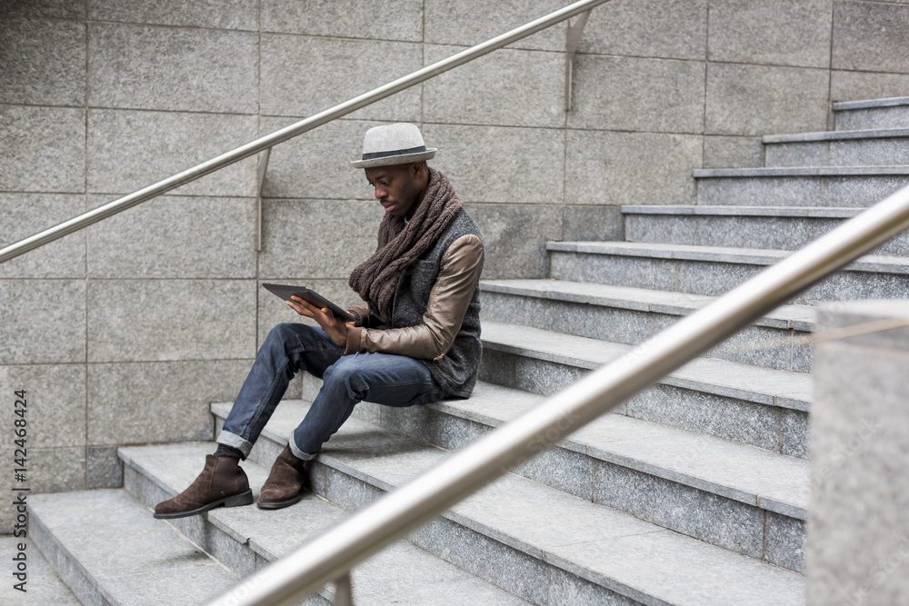 Man sitting on staircase using tablet Man sitting on staircase using tablet