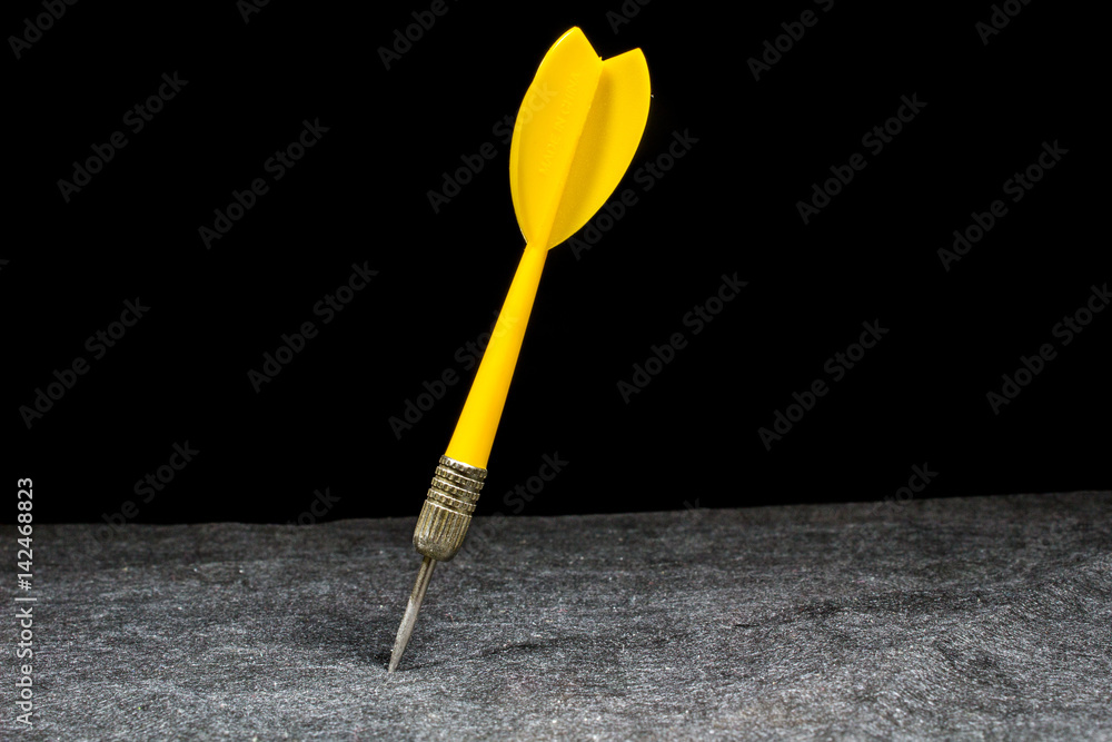Single yellow dart on black background. Single yellow dart on black background.