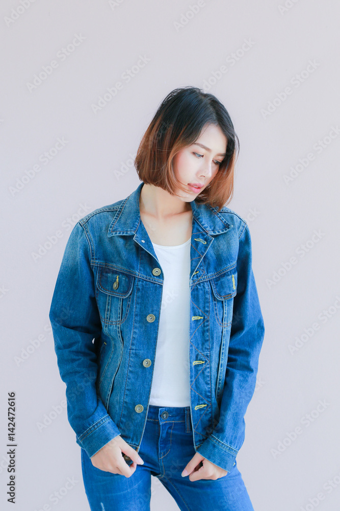 Closeup Asian woman casual outfits standing in jeans and blue denim shirt,  women brown hair and short hair, smiling and wearing jeans jacket, beauty  and fashion Jeans concept, space wall background Stock