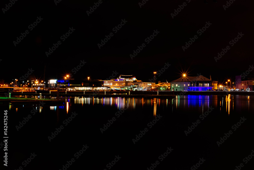 Night fabulous landscape Stockholm harbor, illuminated buildings with reflection in water