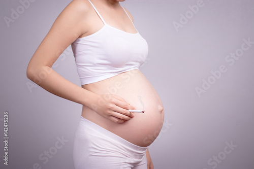 Pregnant healthy concept. Pregnant woman with cigarette in hand , anonymous face