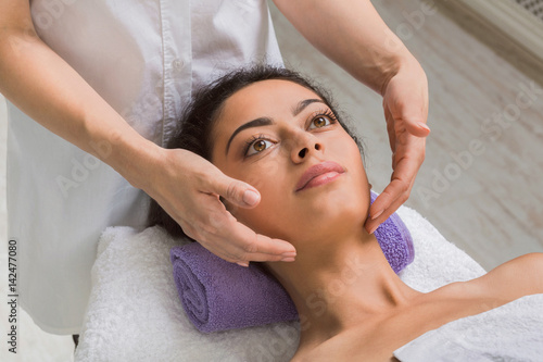 Woman massagist make face lifting massage in spa wellness center