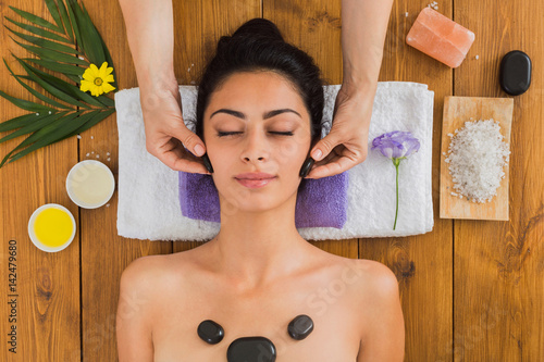 Beautician make stone massage spa for woman at wellness center