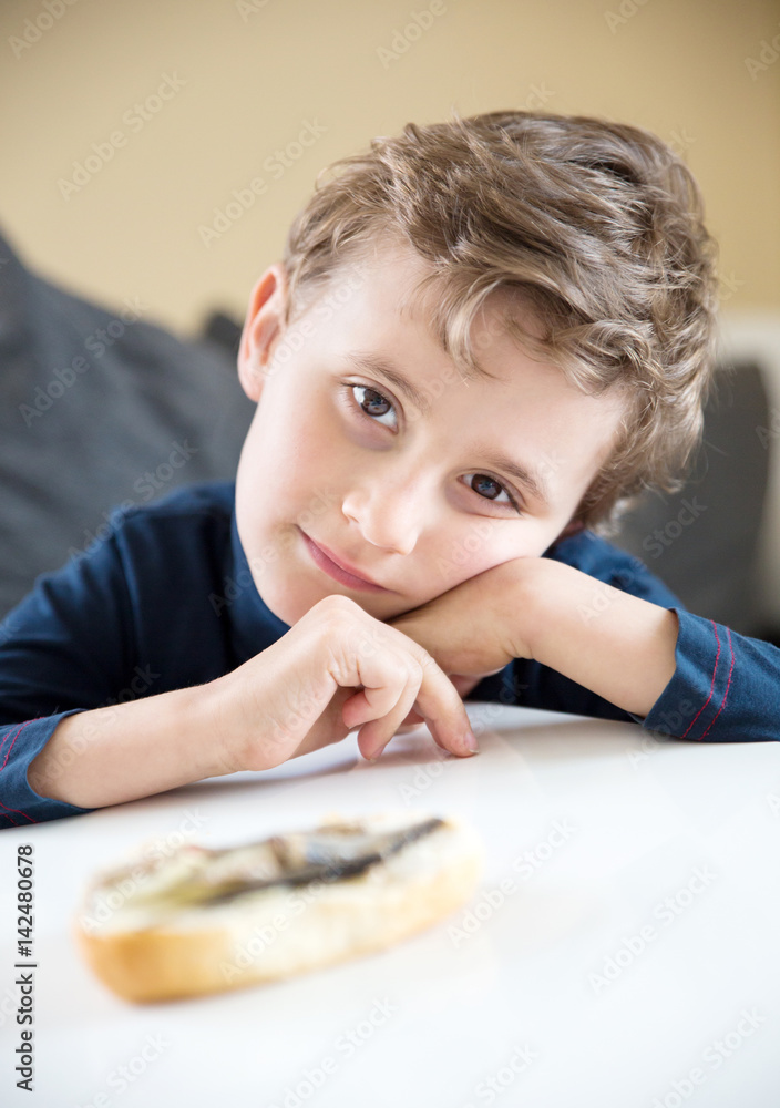 young boy child with brown eyes think about eat the bread or not young boy child with brown eyes think about eat the bread or not