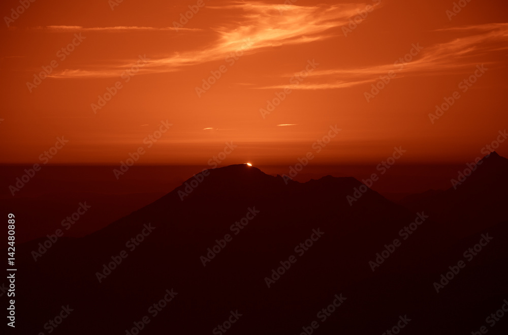 A beautiful, colorful, abstract mountain landscape with sun in a red tonality. Decorative, artistic look.