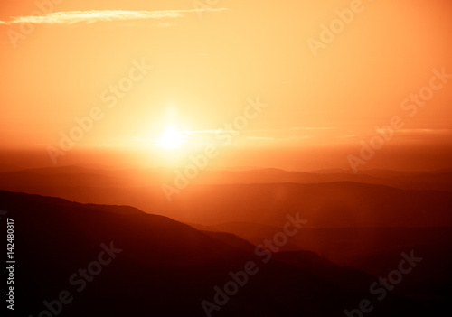 A beautiful, colorful, abstract mountain landscape with sun in a red tonality. Decorative, artistic look.