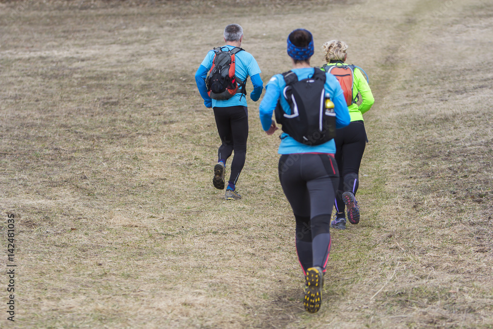 Two women and a man jogging and running outdoors in nature Two women and a man jogging and running outdoors in nature