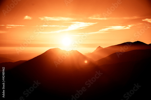 A beautiful  colorful  abstract mountain landscape with sun in a red tonality. Decorative  artistic look.