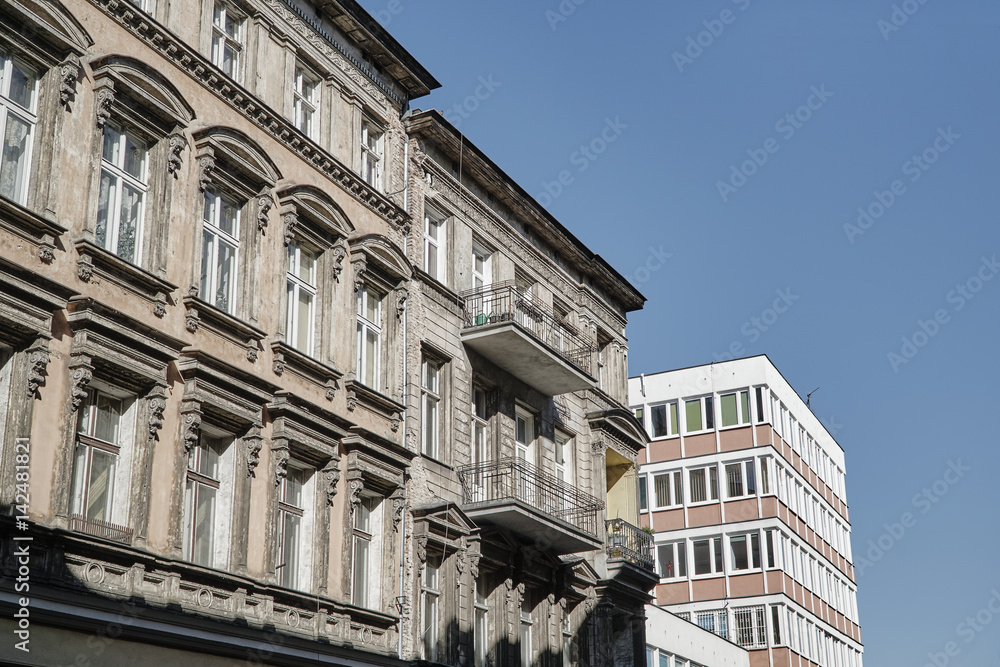 A facade of an Art Nouveau townhouse next to a modernist building in Poznan.