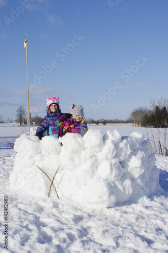 Girls standing in large snow fort