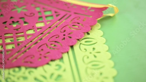 Traditional Mexican papel picado paper banner on a wood background