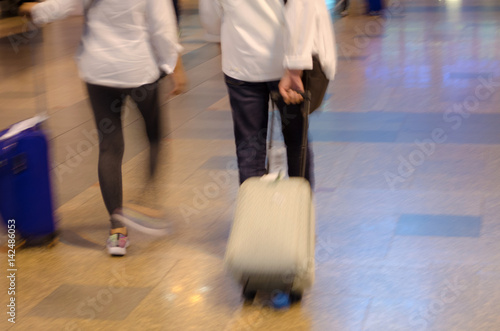 blurred motion of passengers or tourist walking with bag at airport  transportation concept  color tone effect