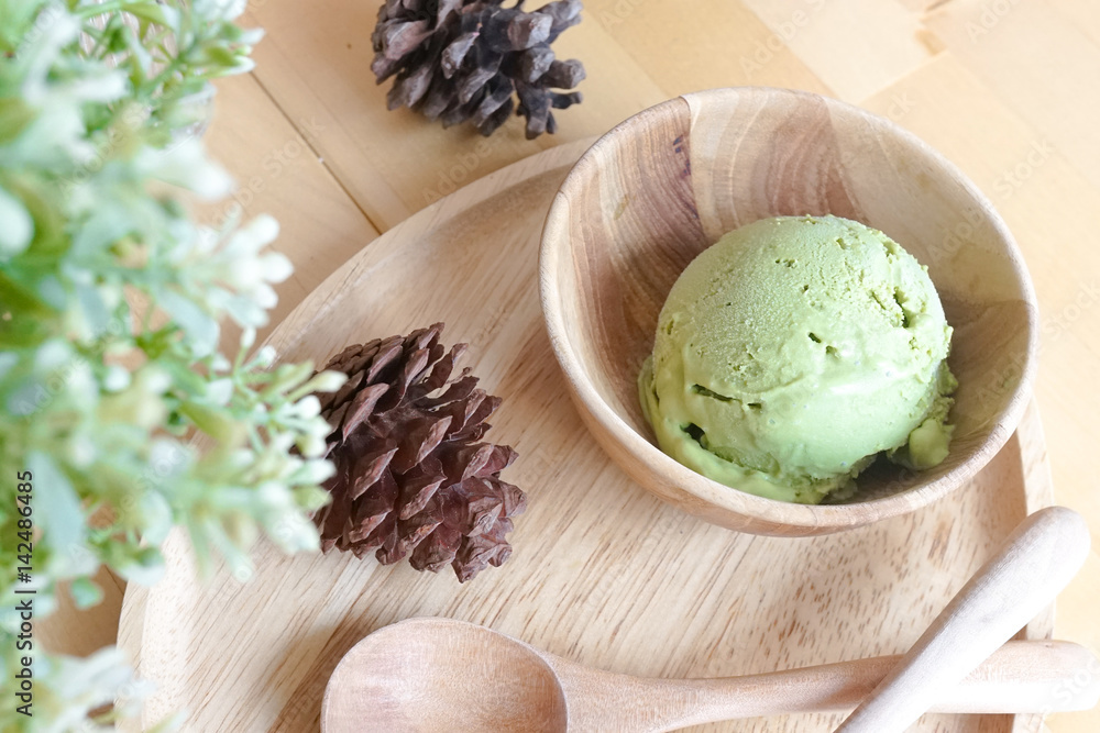 Matcha Green tea ice cream, ice cream served in wooden bowl with wooden spoons Matcha Green tea ice cream, ice cream served in wooden bowl with wooden spoons