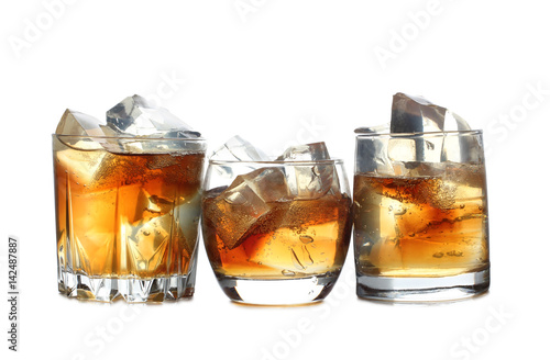 Whiskey and ice in glass on white background
