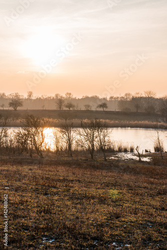 Hazy sunrise over a tranquil farm dam or lake