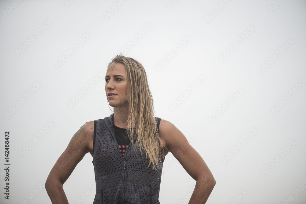 Strong athletic woman with mud on her face after running in rain or extreme sport Strong athletic woman with mud on her face after running in rain or extreme sport